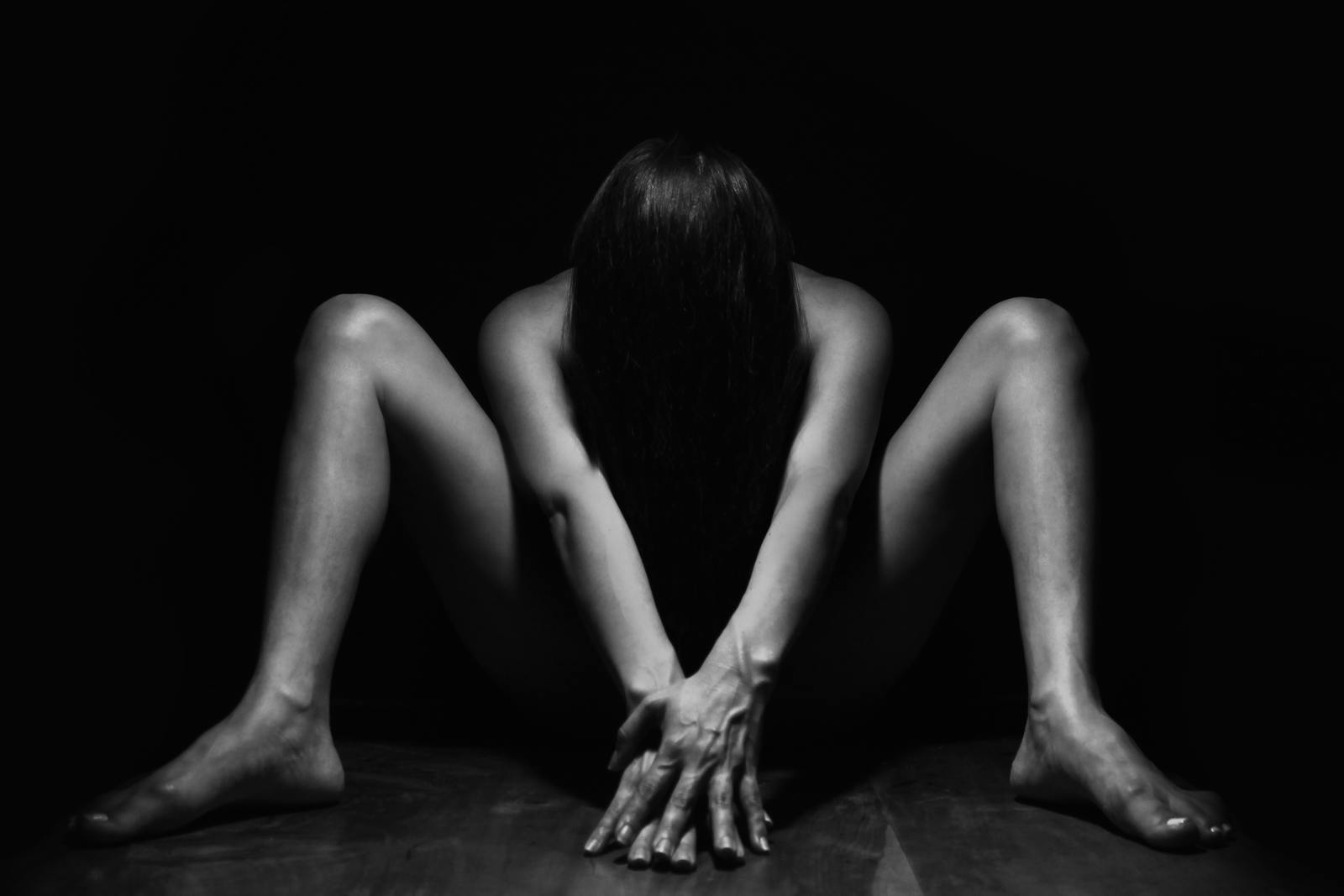 Striking black and white nude portrait capturing artistic expression in a studio setting.